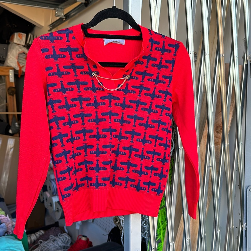 Red blouse with navy blue airplanes on it. Aviation